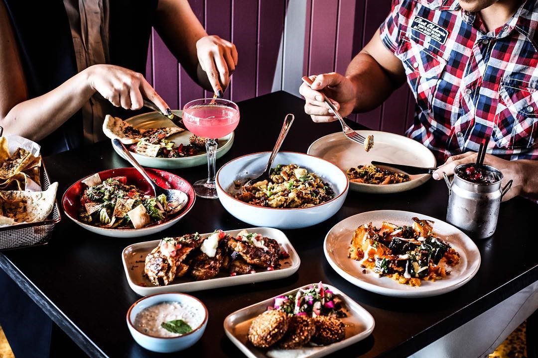 a woman sitting at a table with a plate of food