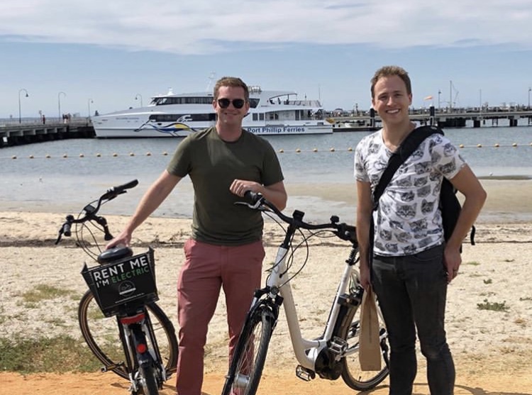 a man and a woman standing next to a bicycle