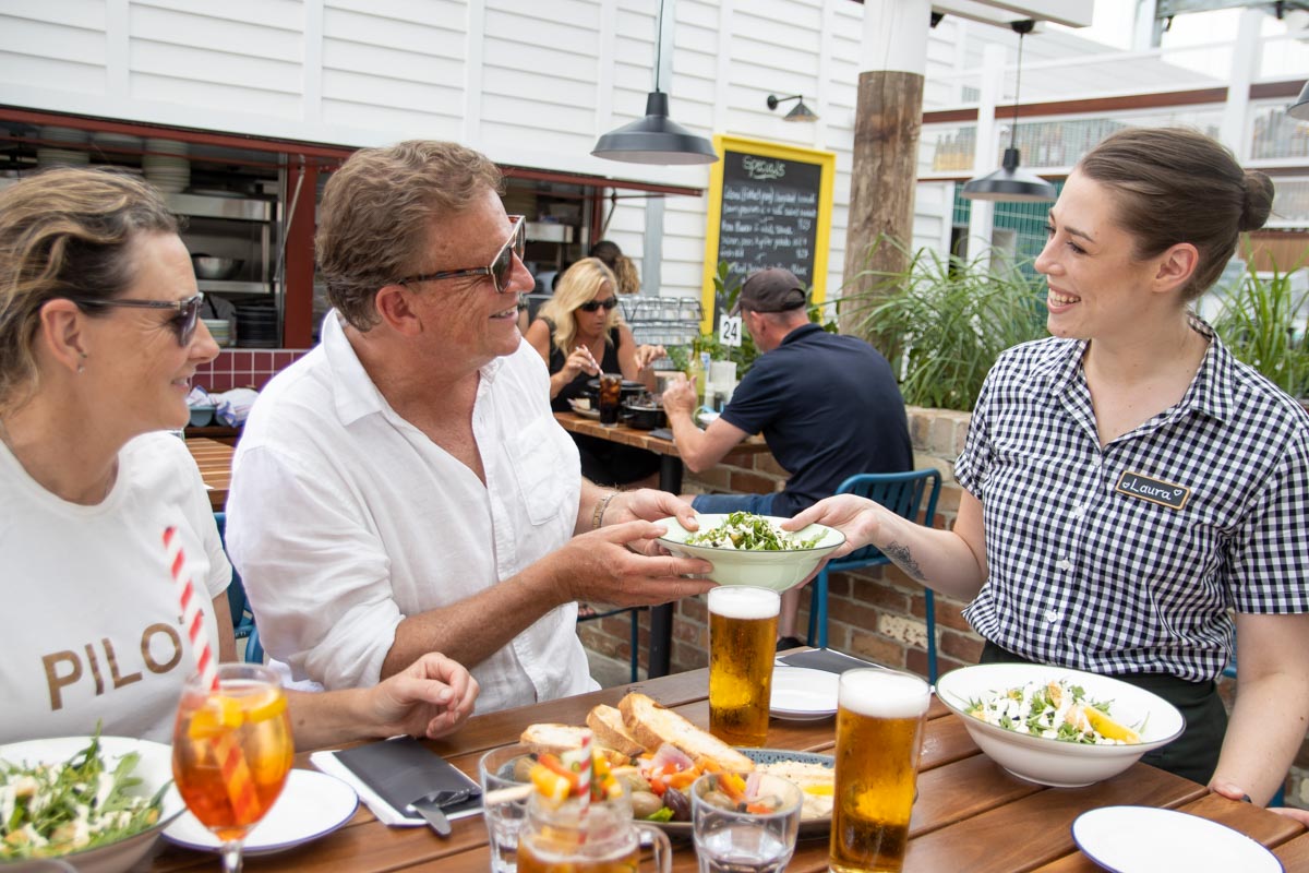 a group of people sitting at a table eating food