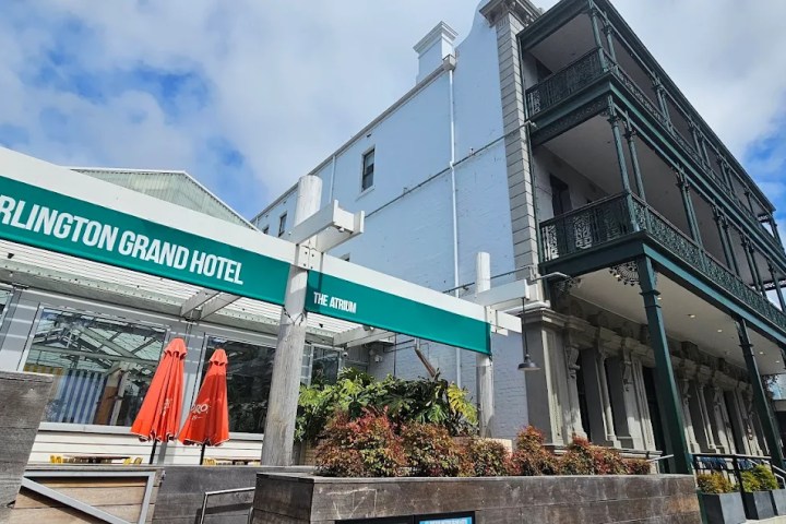 Exterior of Portarlington Grand Hotel with green awnings and outdoor seating.