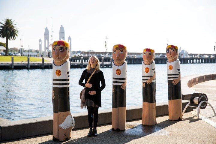 a group of people standing next to a bottle of water