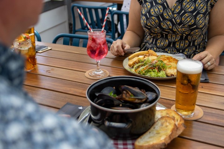 a woman sitting at a table with a plate of food