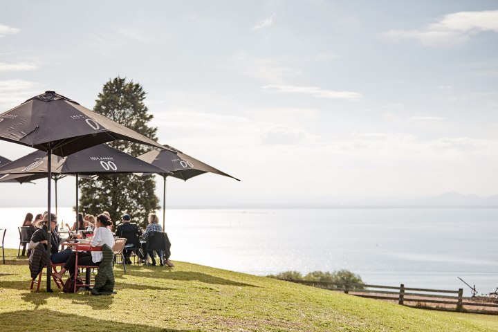 a group of people standing next to a body of water