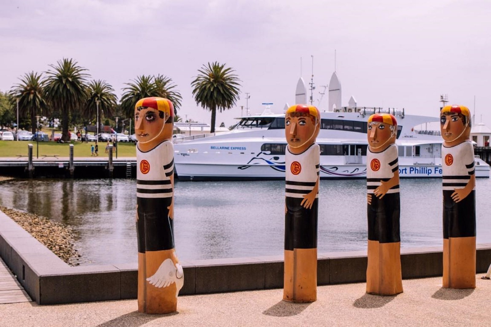a group of palm trees next to a body of water