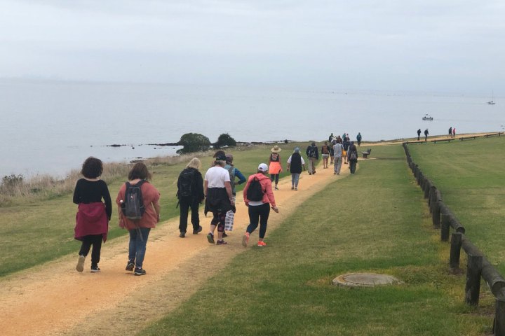 a group of people standing next to a body of water