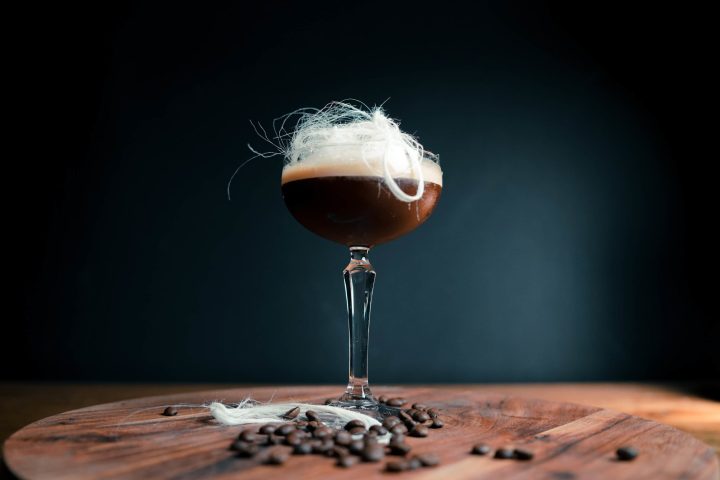 a glass of wine sitting on top of a wooden table