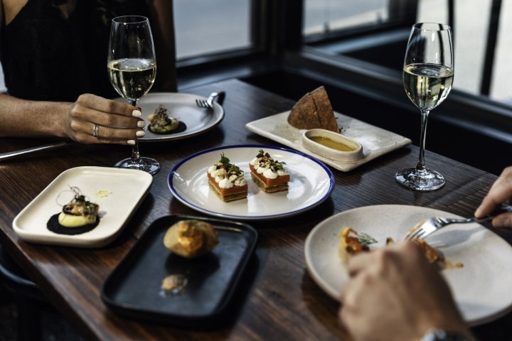 a plate of food and glasses of wine on a table