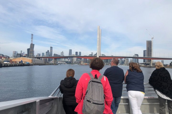 a group of people standing on a bridge over a body of water