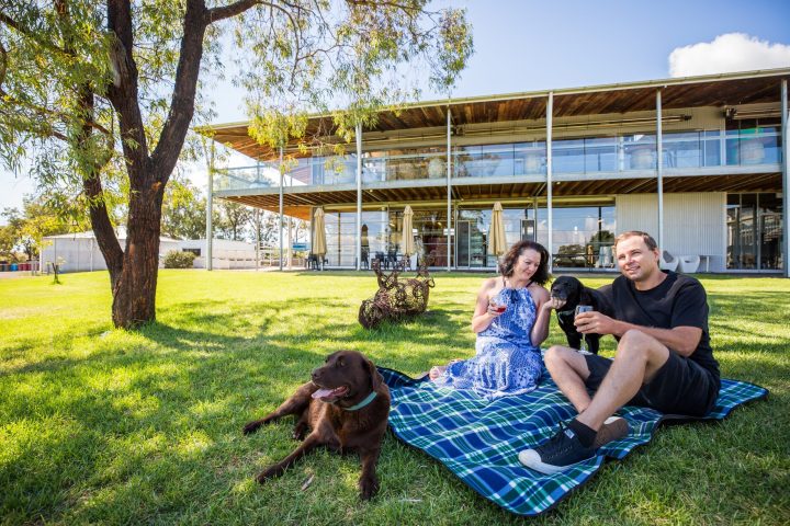a man and a woman sitting on a bench in a park