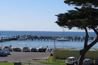 a group of people sitting on a bench next to a body of water