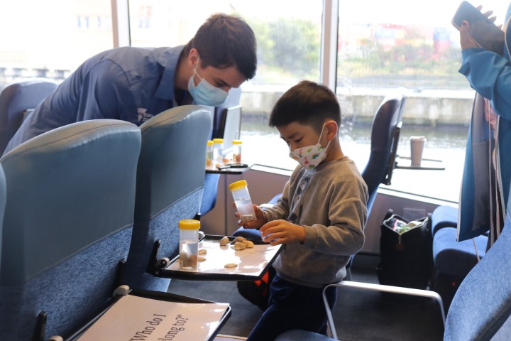 a group of people sitting at a table looking at a laptop