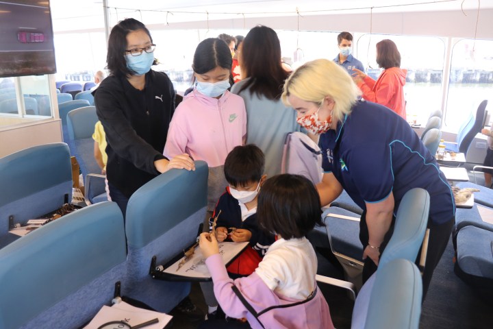 a group of people sitting in a chair talking on a cell phone