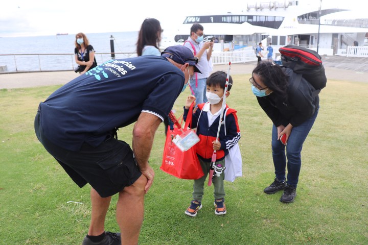 a group of people standing on top of a grass covered field