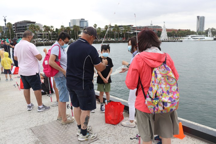 a group of people standing next to a body of water