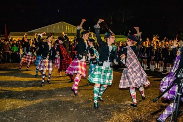 a little girl standing in front of a crowd