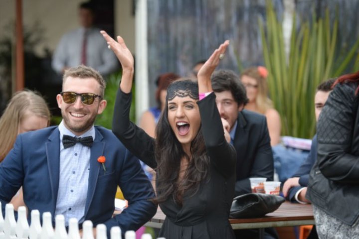 a group of people standing next to a person in a suit and tie