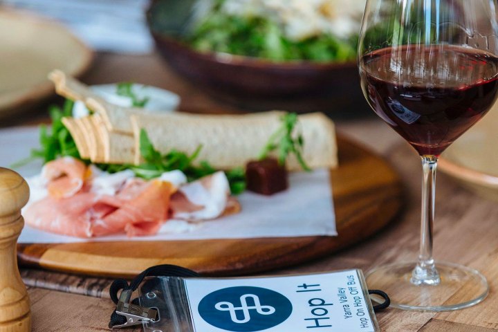 a glass of wine sitting on top of a wooden table