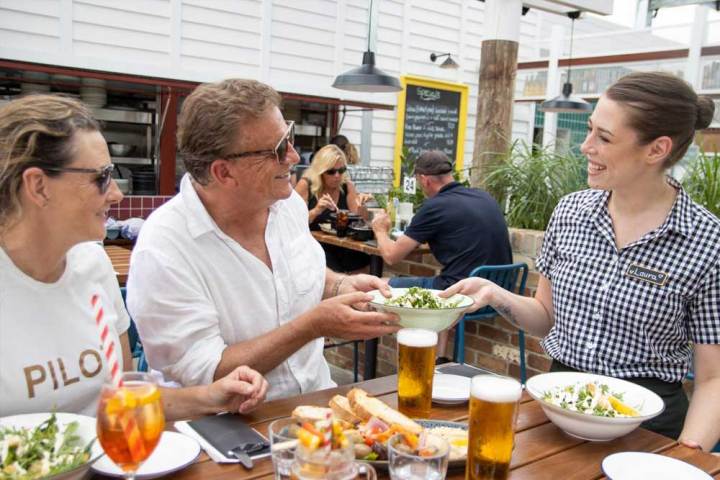 a group of people sitting at a table with a plate of food