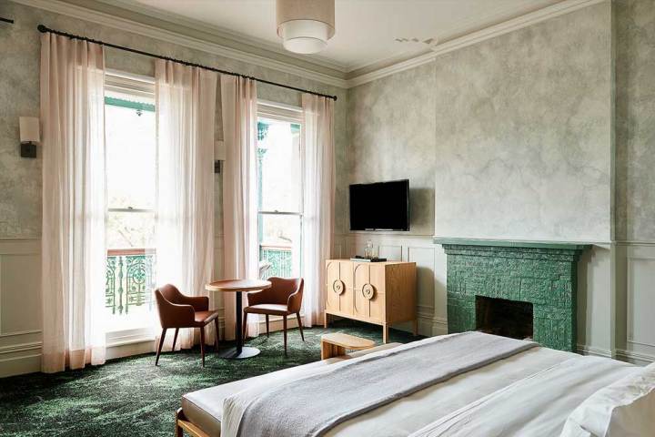 a bedroom with a bed and a chair in a room