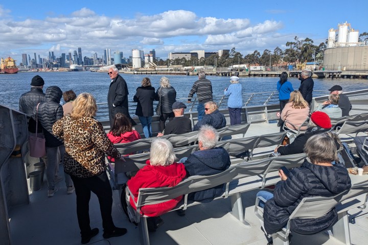 a group of people standing next to a body of water