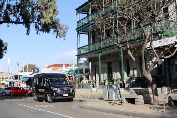 a truck that is driving down the street in front of a building