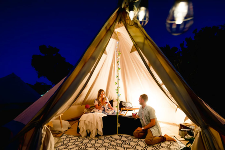 a person sitting in front of a tent
