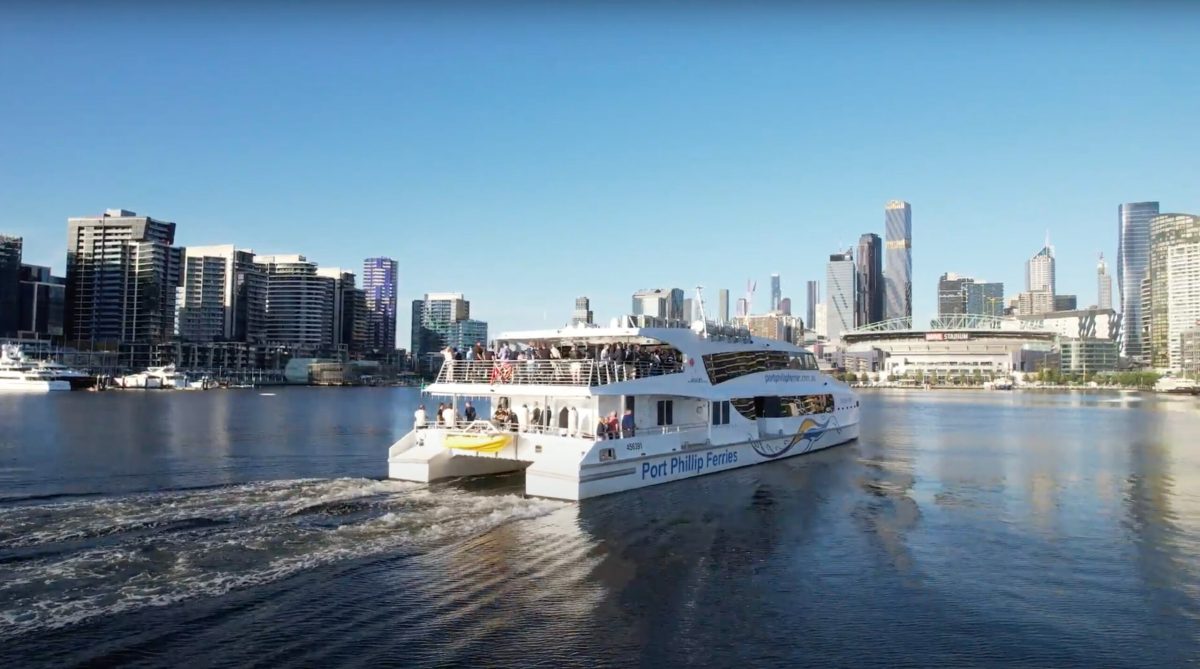 a small boat in a body of water with a city in the background