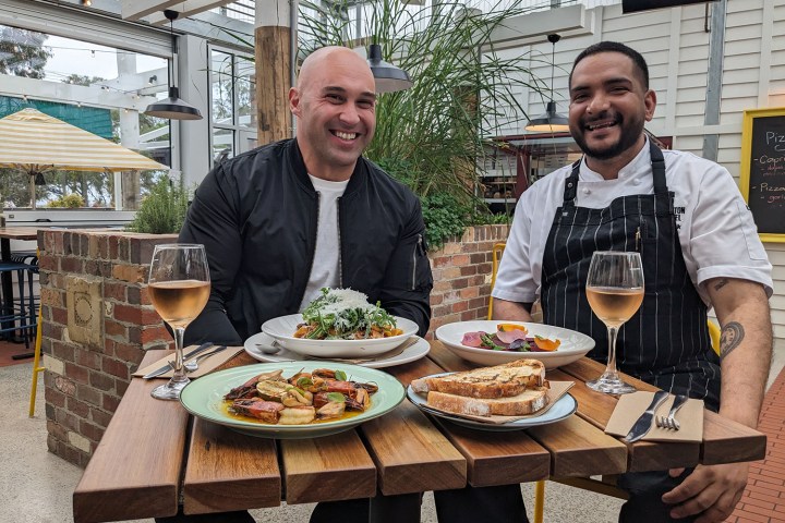 Shane Delia et al. sitting at a table eating food