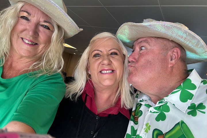 Three people wearing hats, smiling together in a selfie.