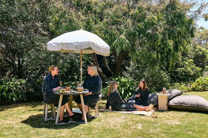a group of people sitting at a table with an umbrella