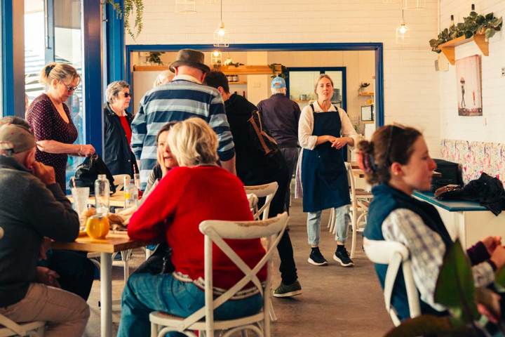 People dining in a cozy cafe with a blue and white decor.