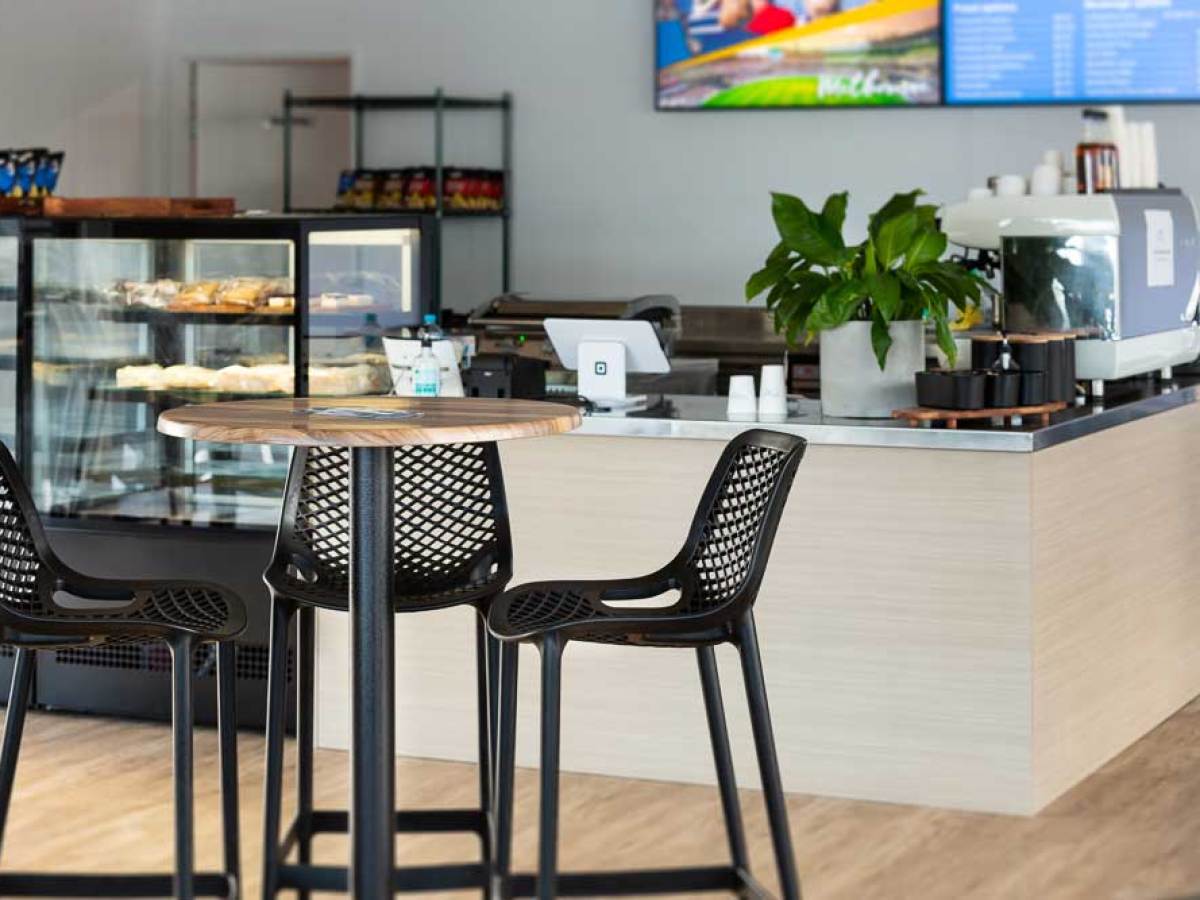 Modern cafe interior with tables, chairs, and a counter.