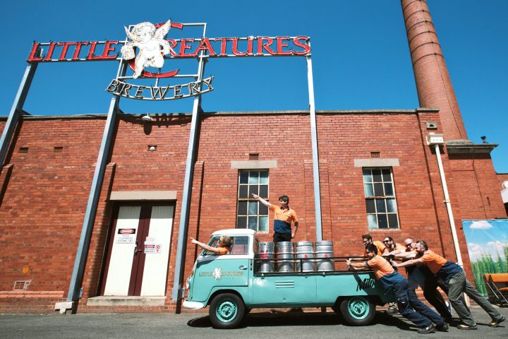 People pushing a truck loaded with beer kegs in front of Little Creatures Brewery.